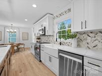 Modern kitchen features white cabinets, marble countertops, and stainless steel appliances at 3417 Chilham Pl, Charlotte, NC 28226