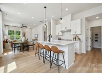 Open concept kitchen with white cabinets, island, and stainless steel appliances at 1194 Lost Cove Rd, Indian Land, SC 29707