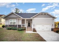 Charming single-Gathering home with gray siding, stone accents, and a welcoming front porch at 159 Rubys Way # 35, Oakboro, NC 28129