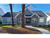 Gray brick and board and batten home with landscaped yard at 405 19Th Avenue Nw Cir, Hickory, NC 28601