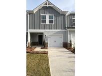 Charming townhome featuring a one-car garage, stylish gray siding and a well manicured lawn at 1618 Village Grove Ln, Monroe, NC 28110