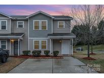 Charming two-story townhome with manicured bushes, green lawn, and a private driveway at 1708 Holliford Ct, Charlotte, NC 28215