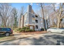 Inviting condo exterior featuring well-manicured landscaping and private balconies, and assigned parking spaces at 2514 Cranbrook Ln # 9, Charlotte, NC 28207