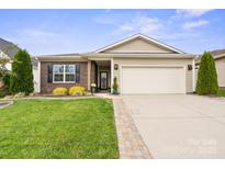 Brick and siding ranch home with landscaped lawn and two-car garage at 5003 Looking Glass Trl, Denver, NC 28037