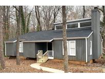 Charming home featuring a gray exterior, complemented by white trim and a cozy front porch with wooden railing at 958 Sherwood Cir, Lancaster, SC 29720