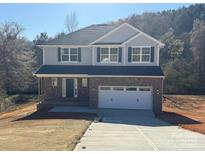 New two-story home with a brick facade, gray siding and two-car garage at 202 Fostoria Pl # 78B, Albemarle, NC 28001