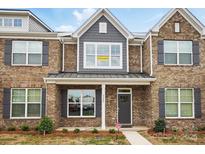 Charming brick townhome featuring gray shutters, craftsman columns, and professionally landscaped yard at 5527 Stafford Rd # 34, Charlotte, NC 28215