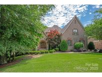 Charming brick home with a beautiful landscaped front yard and architectural details at 1716 Funny Cide Dr, Waxhaw, NC 28173
