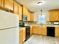 Galley kitchen with wood cabinets and modern appliances at 606 Carver St, Kannapolis, NC 28083