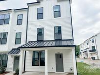 Charming two-story townhouse featuring a modern farmhouse design with white siding and black trim at 13024 Moon Rd # 44, Charlotte, NC 28277