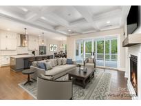 Bright, open-concept living room featuring coffered ceilings, a fireplace, and sliding glass doors to the deck at 267 Triple Ponds Ct # 11, Clover, SC 29710