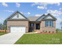 Charming brick home features a manicured lawn, attached garage, and stylish architectural details at 127 Jentri Way, Mooresville, NC 28115