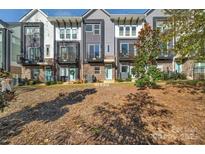 Modern townhomes with gray siding, balconies, and beautifully landscaped front yard at 582 West End Dr, Charlotte, NC 28208