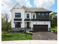 Beautiful two-story home featuring white siding, a stone accent wall, black trim, and a spacious two-car garage at Lot 51 Watercourse Way # Covington, Belmont, NC 28012