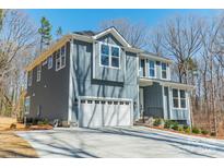 Two-story home with a white garage door, gray siding, and white trim, with well-manicured landscaping at 149 Pinewood St, Troutman, NC 28166