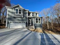 New construction home featuring a gray exterior, white trim, and a two-car garage with driveway at 149 Pinewood St, Troutman, NC 28166