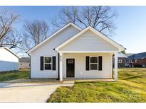 Newly built home with gray siding, a covered porch, and a well-manicured lawn at 805 Cedar St, Salisbury, NC 28144