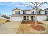 Charming townhome featuring an attached garage and a well-maintained front yard with tasteful landscaping at 2117 Talbert Ct, Charlotte, NC 28214