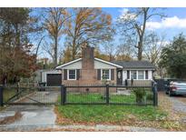 Brick ranch home with a fenced yard and attached garage at 352 Leafmore Dr, Charlotte, NC 28213