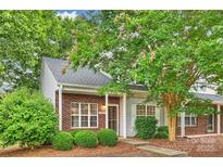 Charming townhouse with brick facade, well-kept landscaping, and mature trees, creating an inviting curb appeal at 14922 Deshler Ct, Charlotte, NC 28273