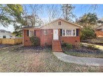 Charming brick home featuring a quaint front yard and inviting front entrance at 4426 Holbrook Dr, Charlotte, NC 28205