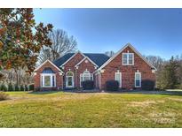 Brick home with landscaped lawn and mature trees at 6146 Highview Rd, Matthews, NC 28104