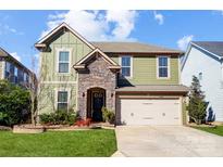 Charming two-story home with a stone archway, complemented by a well-manicured lawn and mature landscaping at 6012 Drave Ln, Fort Mill, SC 29715