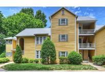 Charming yellow condo with multiple balconies and lush landscaping at 3302 Selwyn Farms Ln, Charlotte, NC 28209