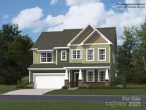 Two-story house with green siding, white garage door, and stone accents at 123 Dogwood Grove Pl, Troutman, NC 28166