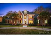 Brick home with columns, balcony, and landscaped yard at 1511 Churchill Downs Dr, Waxhaw, NC 28173