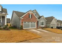 Two-story home with gray siding, brick accents, and a two-car garage at 7014 Jolly Brook Dr, Charlotte, NC 28215