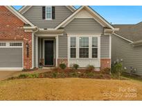 Front entrance of a charming home with gray siding and brick accents at 7014 Jolly Brook Dr, Charlotte, NC 28215