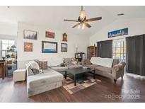 Inviting living room with vaulted ceilings, wood floors, and neutral decor offers an open and airy space at 8931 Meadow Vista Rd, Charlotte, NC 28213