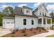 Charming two-story home with a light blue exterior, a white garage door, and a well-manicured front yard at 562 Shepherd Ln, Clover, SC 29710