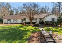 Charming one-story home with manicured lawn, brick pathway, and mature trees at 946 Scotch Dr, Gastonia, NC 28054