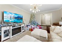 Cozy living room with a fireplace, snowy Christmas tree and gifts surrounding it at 946 Scotch Dr, Gastonia, NC 28054