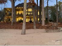 Spacious lake house featuring a sandy beach, outdoor lighting, and a charming lakeside bonfire pit at 1140 Inlet Pointe Rd, Salisbury, NC 28146