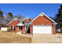 Charming brick home with a red door, white trim, and well-maintained landscaping at 3211 Mcgee Ln, Monroe, NC 28110