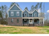 Two-story home featuring a blend of brick and blue siding, complemented by a welcoming front porch at 357 Triple Ponds Ct, Clover, SC 29710