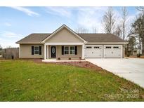 Charming single-story home with a well-manicured lawn and a three-car garage at 190 Williamson St, Troy, NC 27371