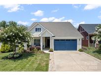 Charming home boasts a blue garage door, well-manicured lawn, and beautiful flowering tree at 467 Granite Lake Ct, Denver, NC 28037