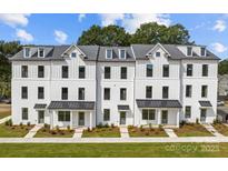 Newly constructed townhomes boast modern white facade, manicured landscaping, and a welcoming curb appeal at 5027 Layman Dr # 24, Charlotte, NC 28226