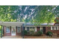 Charming brick home with a covered carport and mature trees, creating a welcoming curb appeal at 116 Lodge Hall Ct, Stony Point, NC 28678