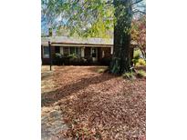 Charming brick home with a spacious front yard covered in fallen leaves, offering a cozy, seasonal appeal at 116 Lodge Hall Ct, Stony Point, NC 28678