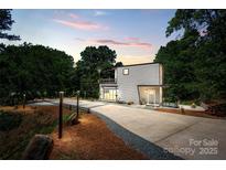 Modern home featuring a sleek exterior, spacious driveway, and lush greenery at 6534 Providence Rd, Charlotte, NC 28226