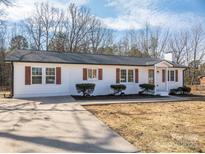 White brick ranch home with brown shutters, landscaping, and a large driveway at 1402 Springdale Park Dr, Lincolnton, NC 28092