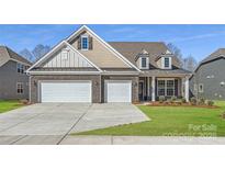 Beautiful brick home featuring a three-car garage and well-manicured lawn at 1603 Croydon St, Indian Land, SC 29707
