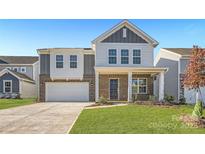 Two-story home with gray and brick exterior, two-car garage, and landscaped lawn at 1614 Cannonball Ln, Bessemer City, NC 28016