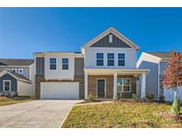 Two-story home with gray and brown siding, a white door, and a driveway at 1614 Cannonball Ln, Bessemer City, NC 28016