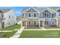 Two-story townhome with gray and blue siding, and a landscaped front yard at 9823 Old Garden Cir, Gastonia, NC 28056